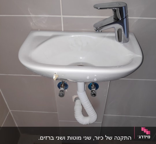 כיור עם ברז וכלי עבודה על הרצפה